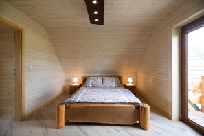 Une chambre à coucher avec un lit en bois, deux lampes de chevet et une grande fenêtre.