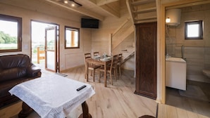 A wooden interior with a dining area, a sofa, and a staircase leading to a bathroom. - Comfortable, Large Holiday Homes With Terraces (Darlowo)