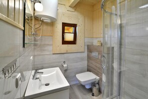 Une salle de bain moderne avec une douche à parois de verre, un lavabo blanc et des toilettes.