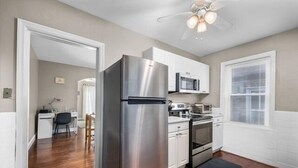 A modern kitchen with stainless steel appliances, white cabinetry, and a wooden floor. - Chic 1BD 1 BA in quiet South City with easy access to I-44, near hospitals, parks, etc. Enjoy a cozy queen bed, full kitchen, fast WiFi, smart TV, and in-unit laundry. Ideal for solo travel, couples, or professionals. Free parking. No pets/smoking. (St. Louis)