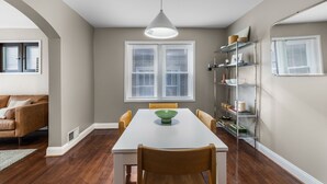 A dining area with a white table, wooden chairs, a green bowl, and a pendant light. - Chic 1BD 1 BA in quiet South City with easy access to I-44, near hospitals, parks, etc. Enjoy a cozy queen bed, full kitchen, fast WiFi, smart TV, and in-unit laundry. Ideal for solo travel, couples, or professionals. Free parking. No pets/smoking. (St. Louis)