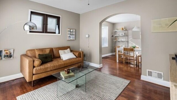 A living room with a brown leather sofa, a glass coffee table, and a ceiling fan. - Chic 1BD 1 BA in quiet South City with easy access to I-44, near hospitals, parks, etc. Enjoy a cozy queen bed, full kitchen, fast WiFi, smart TV, and in-unit laundry. Ideal for solo travel, couples, or professionals. Free parking. No pets/smoking. (St. Louis)