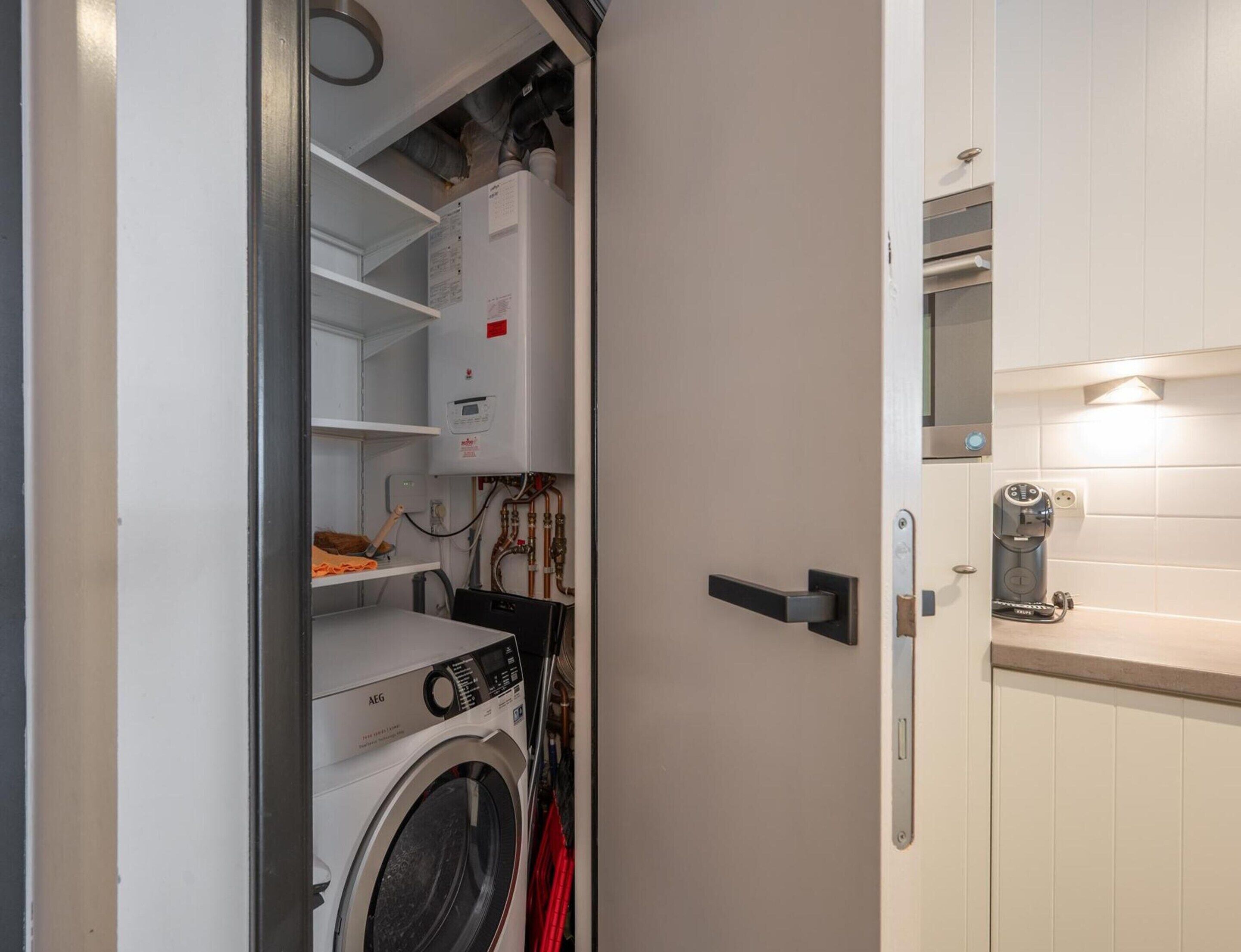 A laundry room with a washing machine, a dryer, and a water heater.