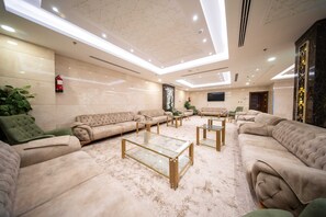 A spacious lobby with plush seating, a glass coffee table, and a modern ceiling design. - Tamore Hotel By Orvana (Makkah)