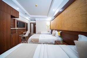 A hotel room with two beds, a desk, a TV, and a decorative wall panel. - Tamore Hotel By Orvana (Makkah)