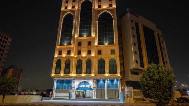 Un hôtel au design architectural classique, caractérisé par de grandes fenêtres en arc et une entrée imposante.