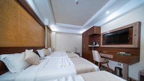Une chambre d’hôtel avec deux lits, une télévision, un bureau et une chaise.