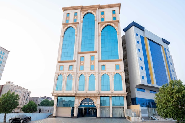 Een hotel met een klassiek architectuurontwerp, met grote boogvensters en een opvallende entree.