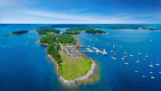 An aerial view of a coastal area with a marina, several islands, and boats. - Eider Haven: 1  BR, 1  BA Cottage in Harpswell, Sleeps 4 (Harpswell)
