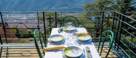 Mesa para cuatro personas con vistas panorámicas a montañas y un pueblo al fondo.