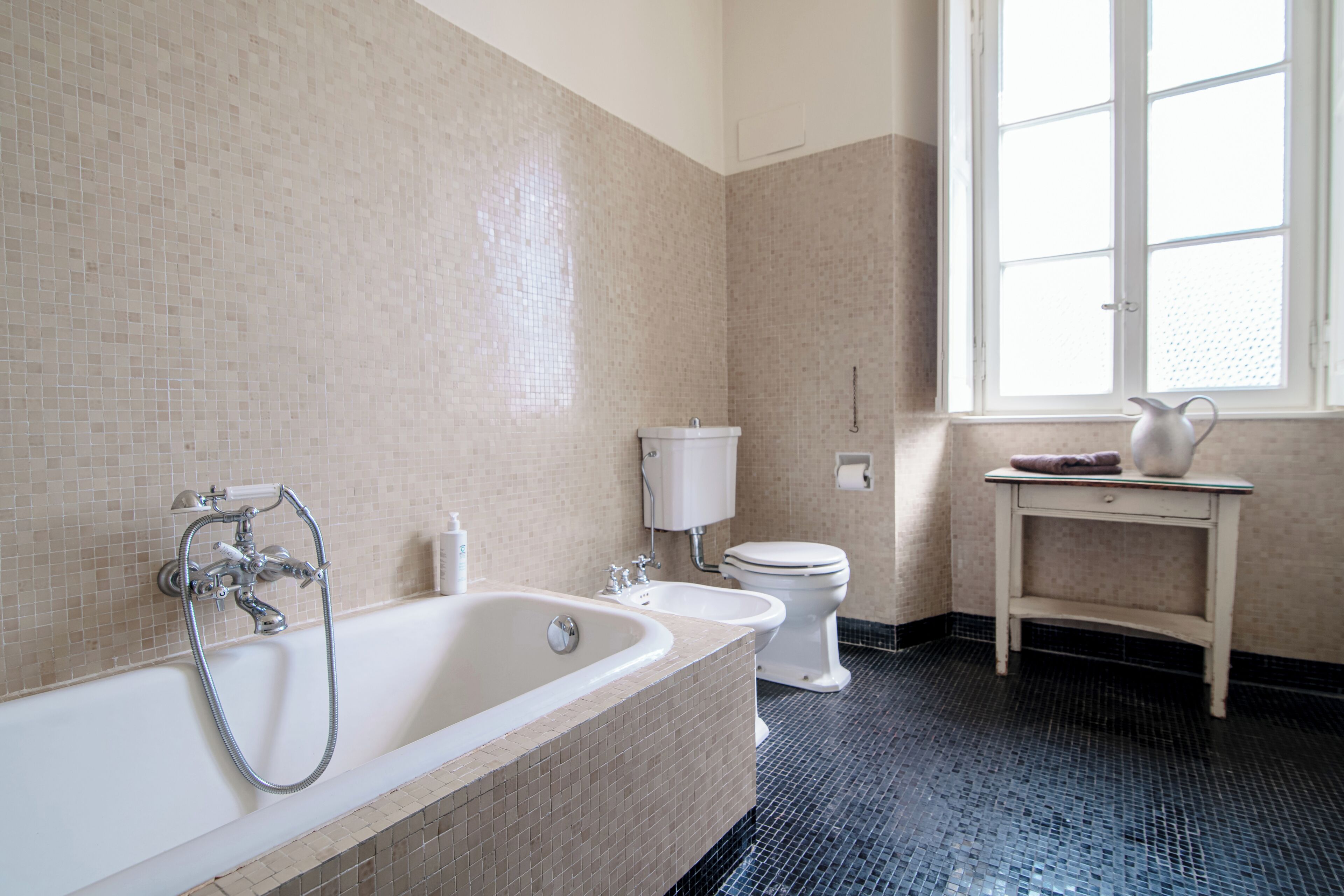 A bathroom with a bathtub, toilet, and sink.