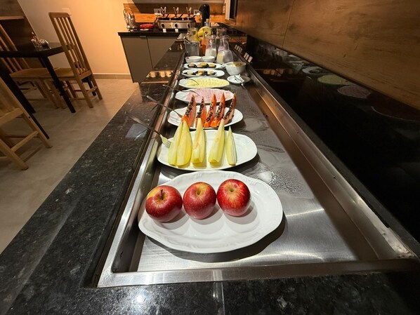 A buffet setup with various food items and utensils.