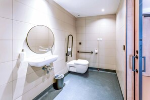 A modern bathroom with a sink, mirror, toilet, and handrail. - easyHotel Alicante Centro (Alicante)