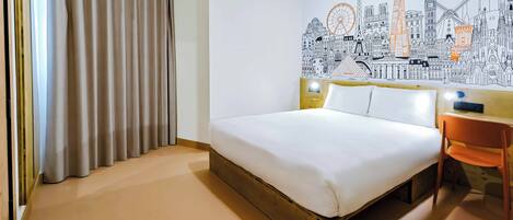 Habitación de hotel con cama, una silla, un mural en la pared y una ventana con cortinas.
