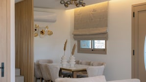Un interno moderno con zona pranzo, una scala e un'ampia finestra con vista.