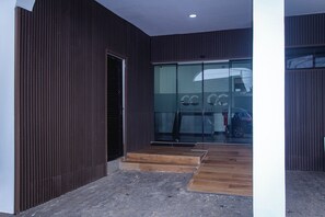 A modern building entrance with a wooden staircase leading to a glass door. - C & C Luxury Suites (Lagos)