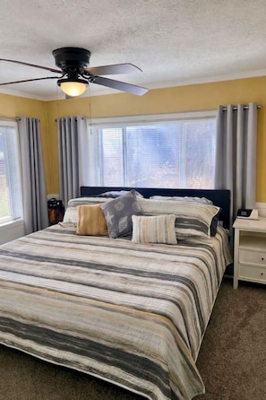 A bedroom with a bed, a ceiling fan, a nightstand, and a window with curtains. - Relax, Paddle, Bonfire, take in the fall colors. (Brooklyn)