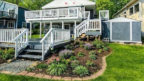 A two-story house with a balcony, a garage, and a well-maintained garden.