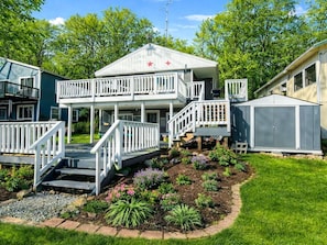 Ein zweistöckiges Haus mit Balkon, Garage und einem gepflegten Garten.
