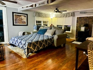A bedroom with a bed, a sofa, a table, a water dispenser, and a fireplace. - Relax, Paddle, Bonfire, take in the fall colors. (Brooklyn)