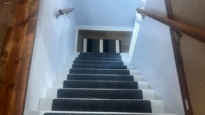 A wooden staircase leading to a landing with a white door.
