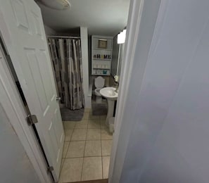 Ein Badezimmer mit Toilette, Waschbecken und Duschvorhang.