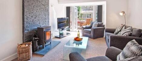 A living room with a fireplace, a television, a sofa, and a coffee table.