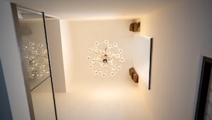 A modern interior with a unique chandelier, a glass partition, and a wooden accent. - Stunning 3 Bed Converted Village Hall Near Kelso (Kelso)