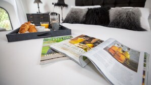 A neatly made bed with a magazine, a tray with croissants, and a glass of orange juice. - Stunning 3 Bed Converted Village Hall Near Kelso (Kelso)