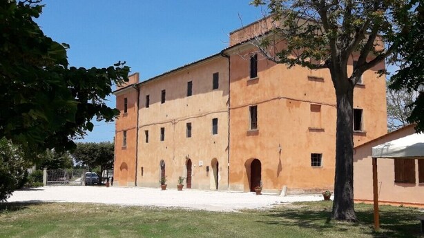 Un edificio ampio e basso, con facciata simmetrica, numerose finestre e un ingresso centrale.