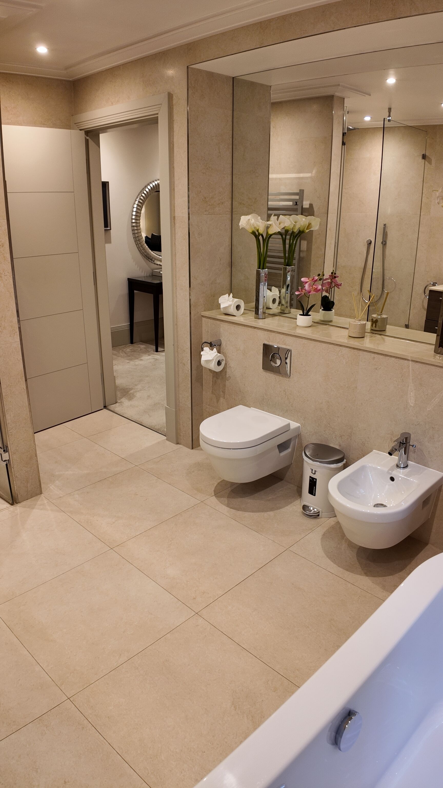Une salle de bain moderne avec une baignoire, deux lavabos, des toilettes et un grand miroir.