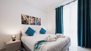 Ein modernes Schlafzimmer mit Bett, Nachttisch und einem Bild an der Wand.