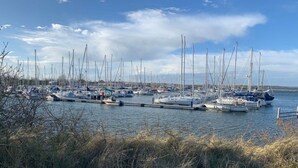 Un port de plaisance où sont amarrés de nombreux voiliers le long de la côte.