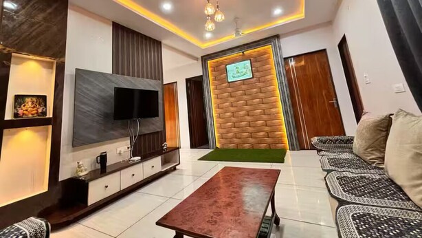 Una sala de estar moderna con una televisión de pantalla plana, una pared de acento de madera, un sofá y una mesa de centro.