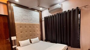 Un dormitorio moderno con una cama grande, ventilador de techo y aire acondicionado.