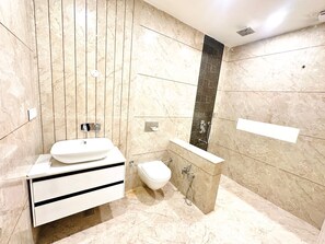 Un bagno moderno con un vanità in marmo, un water e zona doccia.