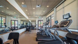 Una palestra con tapis roulant, macchinari per pesi e attrezzature per esercizi.