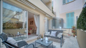 A cozy outdoor seating area with a table, chairs, and a bottle of wine. - 3 Pieces EN Duplex Terrasse Centre Ville A2b103 (Cannes)