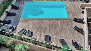 An outdoor swimming pool with lounge chairs and a wooden deck. - Elegant 2 Pieces Piscine Proche Plages A1b235 (Cannes)