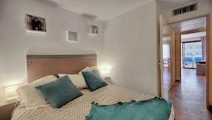 A bedroom with a bed, bedside tables, and a view of the outside. - Elegant 2 Pieces Piscine Proche Plages A1b235 (Cannes)