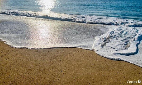 Una playa con olas y luz solar.