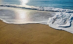 Μια παραλία με απαλούς κυματισμούς που σκάνε απαλά στην ακτή.