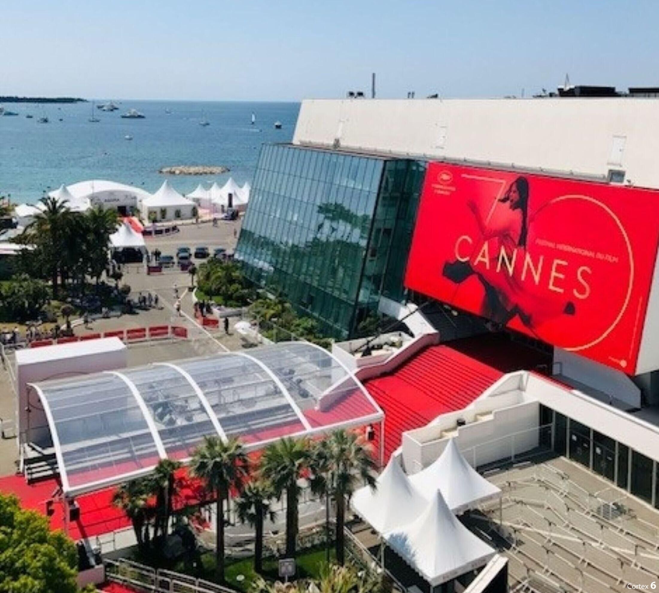 A modern building with a large red banner advertising the Cannes Film Festival.
