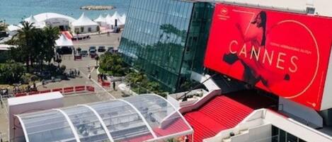 A modern building with a large red banner advertising the Cannes Film Festival.