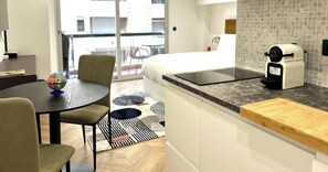 Eine moderne Küche mit Arbeitsplatte, einer Kaffeemaschine und einem Essbereich mit Tisch und Stühlen.