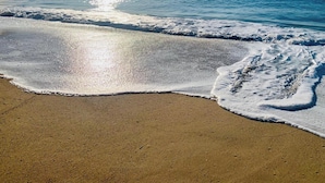 Une plage où les vagues viennent doucement lécher le rivage.