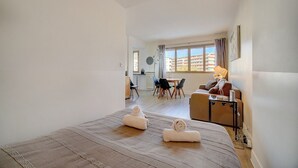 Habitación de hotel con cama, escritorio, silla, mesa de comedor y vista a la ciudad.