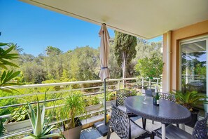 A balcony with a round table, chairs, and a bottle of champagne. - 3 Chambres 1 SDB Terrasse Piscine Parking A3b134 (Cannes)