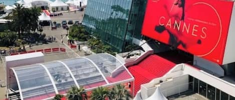 A modern building with a large red billboard advertising Cannes.