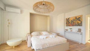 Un dormitorio moderno con cama, mesitas de noche, una estantería en la pared y un cuadro grande.